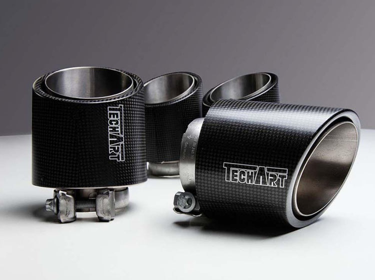 A close up view of TECHART Tail Pipe Kit Titanium With Carbon Trim For Rear Muffler Porsche Cayenne