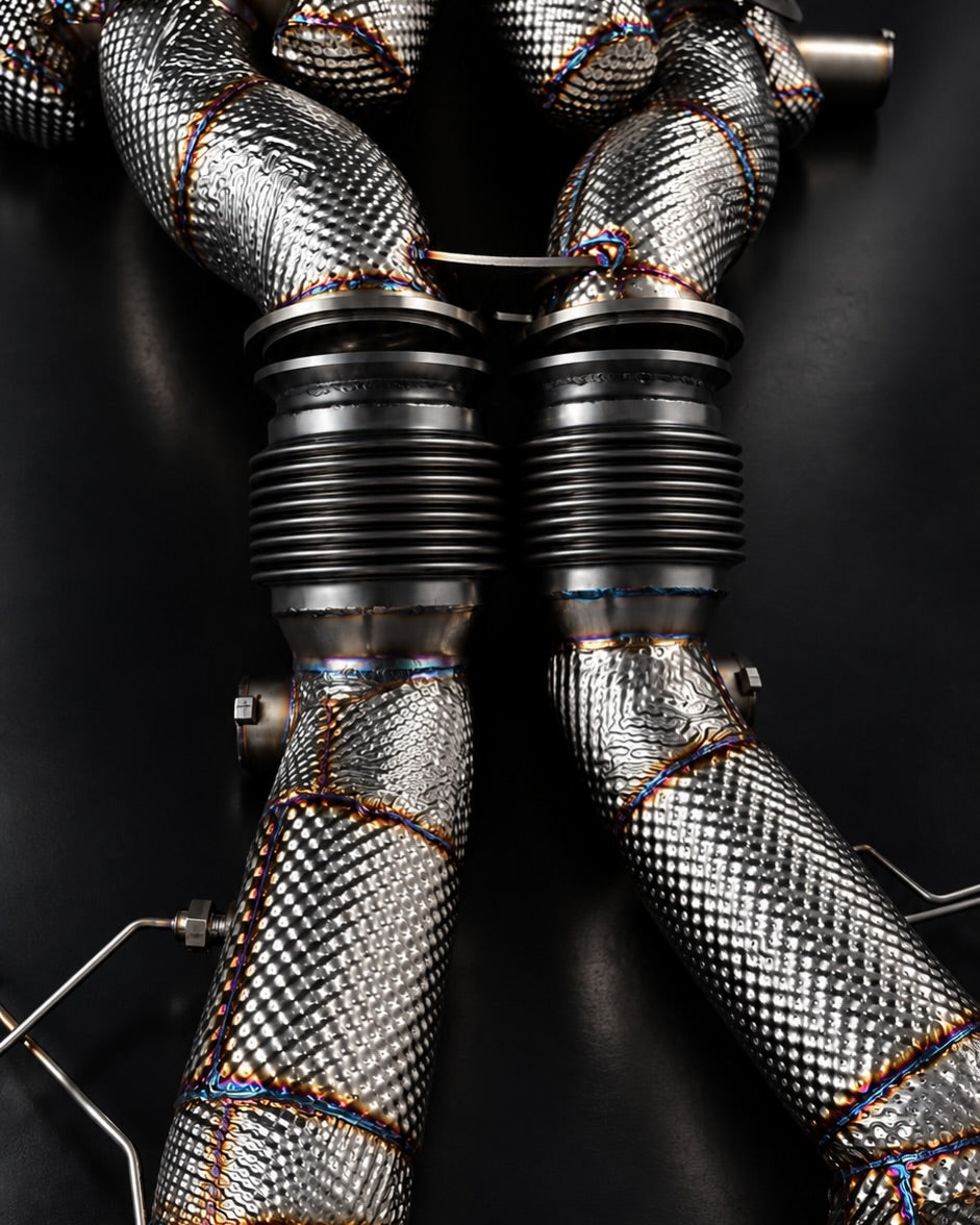 Temerario downpipes from above showing flex bellows and heat-protection wrap