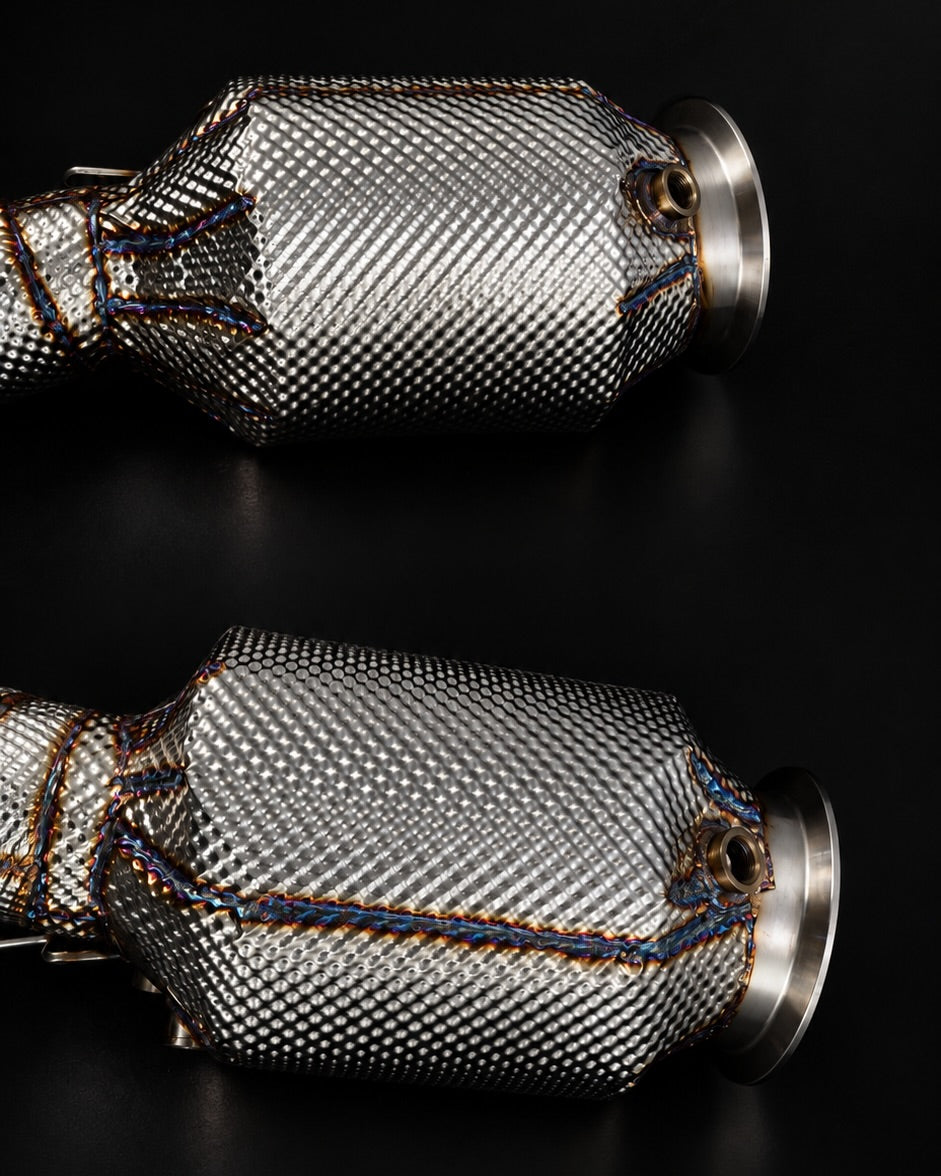 Close-up of heat-wrapped Temerario downpipe sections with V-band flanges and sensor ports