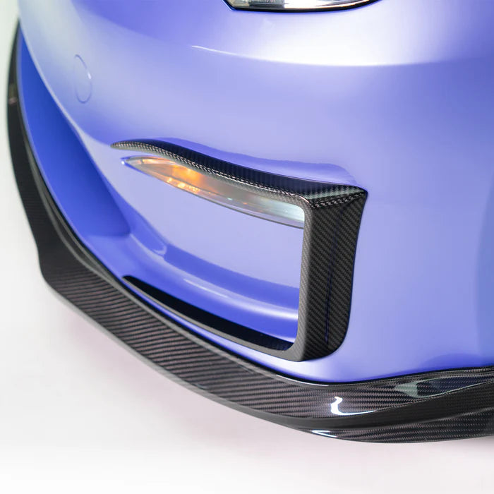 A close up view of a car fitted with Vorsteiner VRS Plaid Add-On Aero Bumper Flares Carbon Fiber PP 2x2 Glossy for Tesla Model S 2021+ with white background