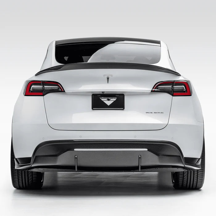 A wide view of Vorsteiner VRS Aero Decklid Spoiler Carbon Fiber PP 2x2 Glossy fitted on a white car from behind (for Model Y).