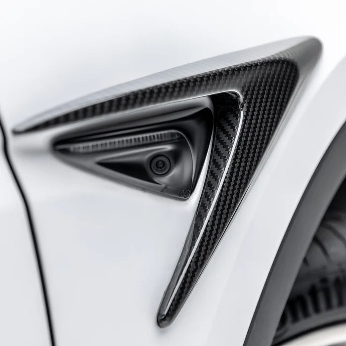 A close up view of Vorsteiner VRS Add-On Aero Fender Vents Carbon Fiber PP 2x2 Glossy on a white car (for Model Y). 
