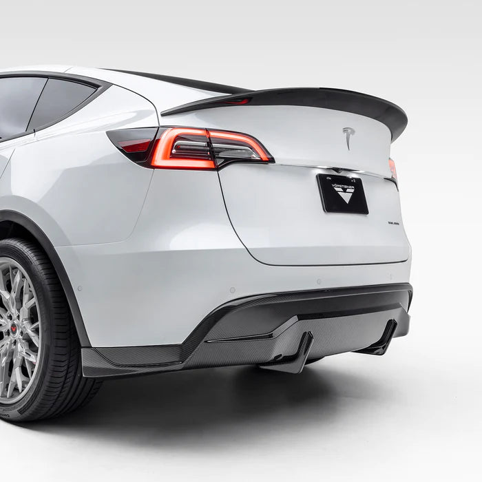 A view of Vorsteiner VRS Aero Rear Diffuser Carbon Fiber PP 2x2 Glossy fitted on white car from behind (for Model Y).