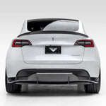 A wide view of Vorsteiner VRS Aero Rear Diffuser Carbon Fiber PP 2x2 Glossy fitted on white car from behind (for Model Y).