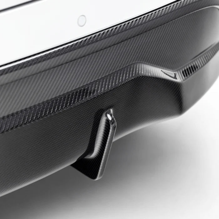 A close view of Vorsteiner VRS Aero Rear Diffuser Carbon Fiber PP 2x2 Glossy fitted on white car (for Model Y).