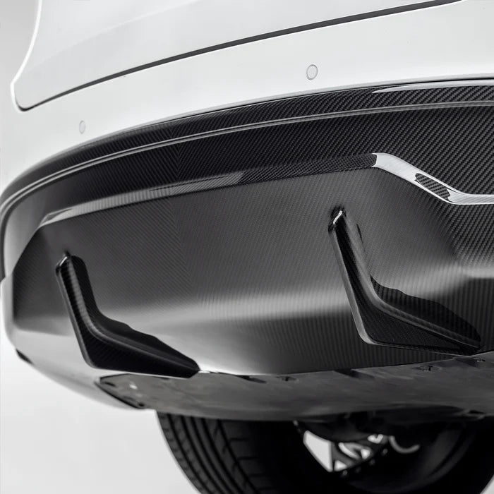 A close view of Vorsteiner VRS Aero Rear Diffuser Carbon Fiber PP 2x2 Glossy fitted on white car (for Model Y).