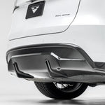 A close view of Vorsteiner VRS Aero Rear Diffuser Carbon Fiber PP 2x2 Glossy fitted on white car (for Model Y).
