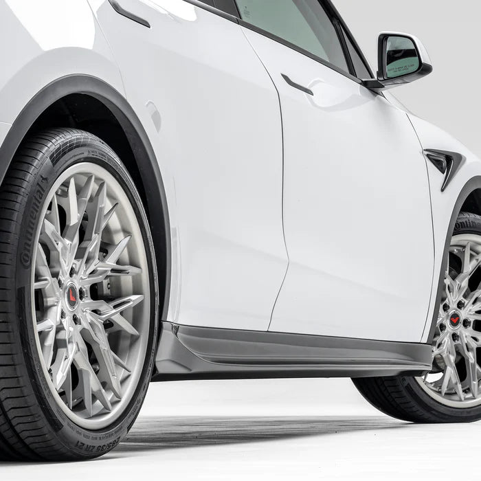 A side view of Vorsteiner VRS Aero Side Skirts Carbon Fiber PP 2x2 Glossy fitted on a white car (for Model Y).