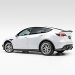 A wide side view of Vorsteiner VRS Aero Side Skirts Carbon Fiber PP 2x2 Glossy fitted on a white car (for Model Y).