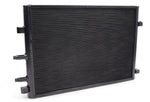 A side-angled view of the VRSF Front Mount Heat Exchanger Upgrade for BMW M2C, M3, and M4 (S55 engine). The high-performance radiator features a large, rectangular core with a dense fin design and a sleek black powder-coated finish. The left side displays two hose connection ports and heavy-duty mounting tabs, showcasing the robust TIG-welded construction designed for improved cooling efficiency on a white background.