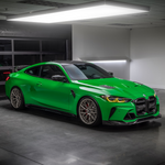 Green G80 M3 with GTS-V bumper in garage, front 3/4 view