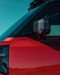 Close-up of the Urban XRS carbon mirror cover fitted to a red Land Rover Defender