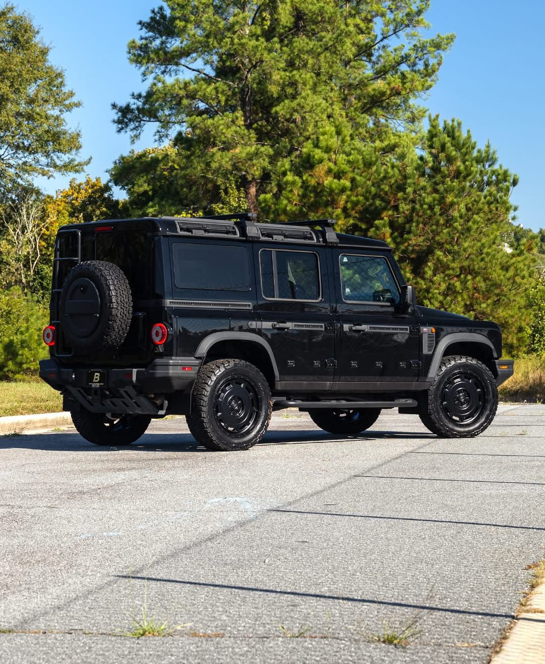 INEOS Grenadier on Urban WX4 satin black wheels, rear three-quarter view (other accessories shown are not included)