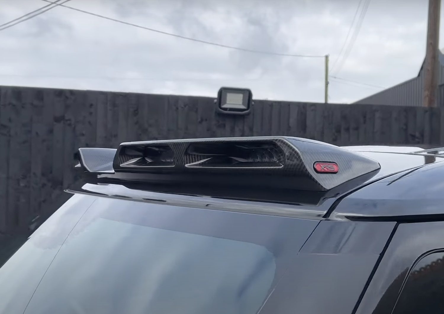 A back close up view of Urban Automotive XRS Limited Edition Carbon Quad-Pod Lazer Lightbar for Land Rover L663 Land Rover Defender 90 / 110 / 130 2020-2025 fitted on a car