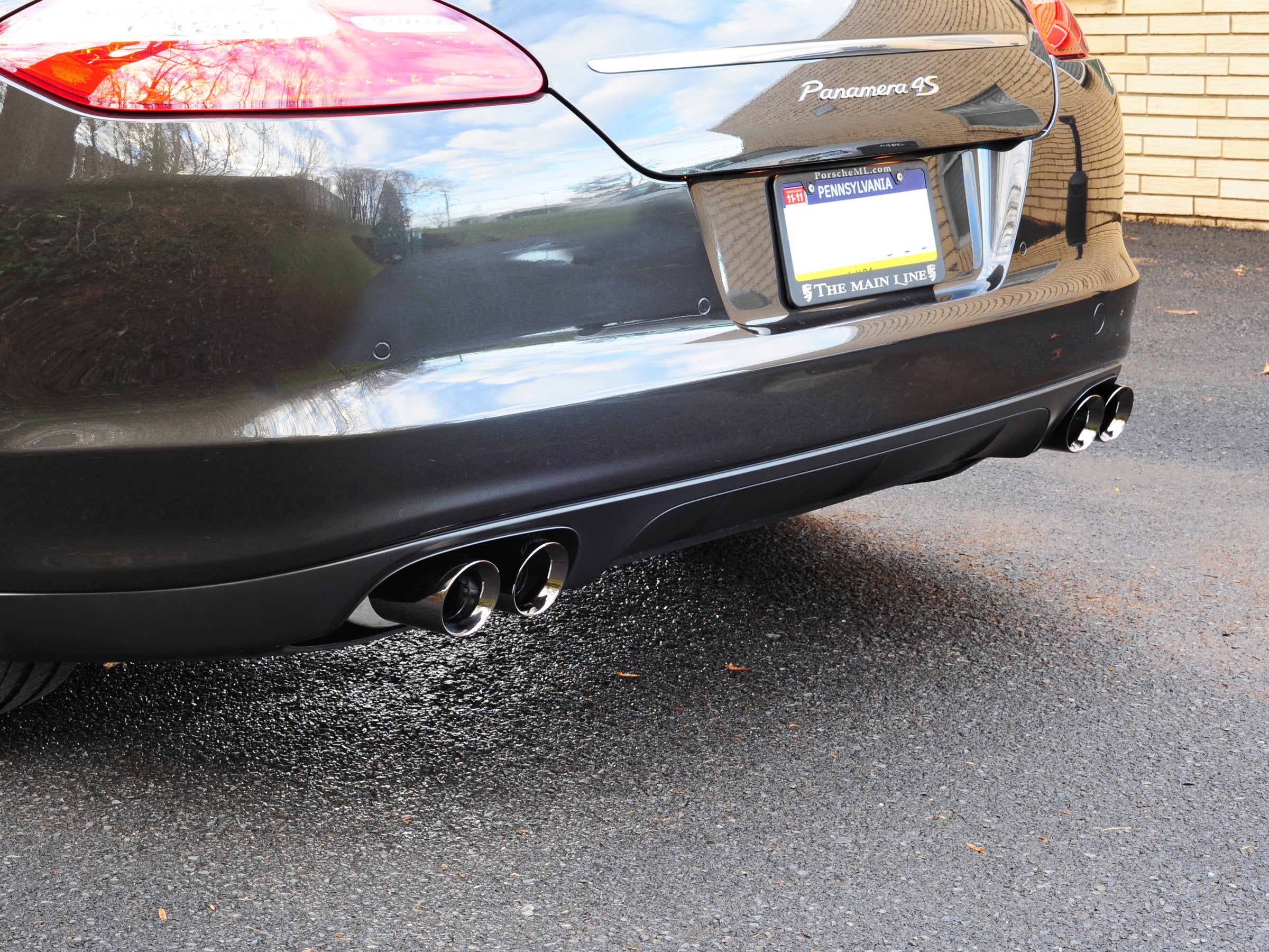 Rear of a dark grey Porsche Panamera 4S showing AWE polished silver quad tips on both sides