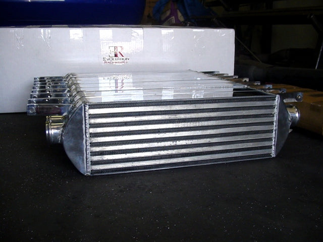 A front view of Evolution Racewerks Audi A4 (B6) Sports Series Front Mount Intercooler (FMIC) Kit fresh off production line on a table with the box behind it