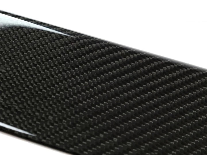 A close up view of AUTOTECKNIC DRY CARBON FIBER SIDE SILL SET - BMW G01 X3 | G02 X4 2018+ with white background