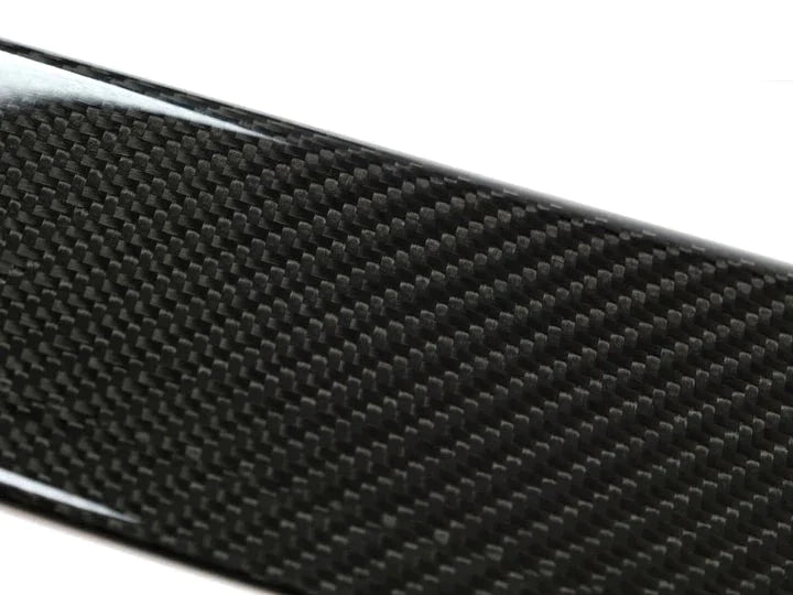 A close up view of AUTOTECKNIC DRY CARBON FIBER SIDE SILL SET - BMW F97 X3M | F98 X4M 2019+ with white background