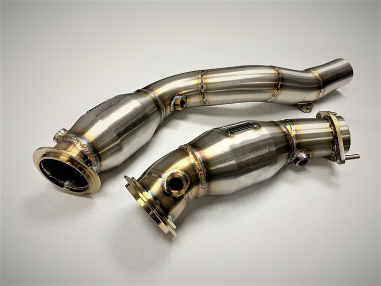 A top view of Evolution Racewerks Sports Series High Flow Catted Downpipes BMW M3/M4 S55 Engine in Brushed Finish