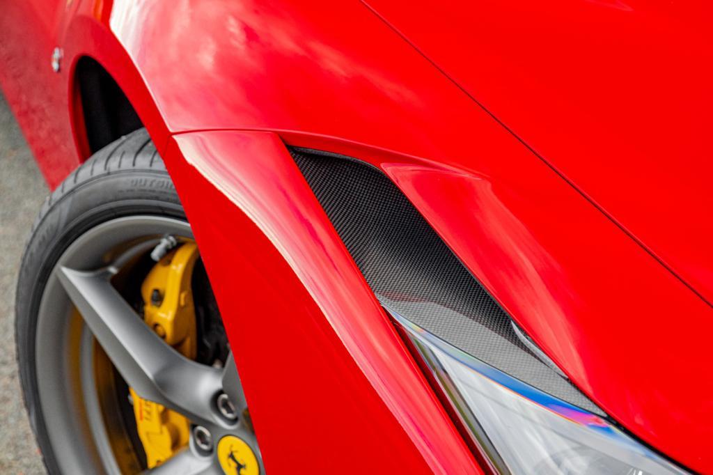 Close-up of Capristo carbon headlight vent above the front wheel of a red F8