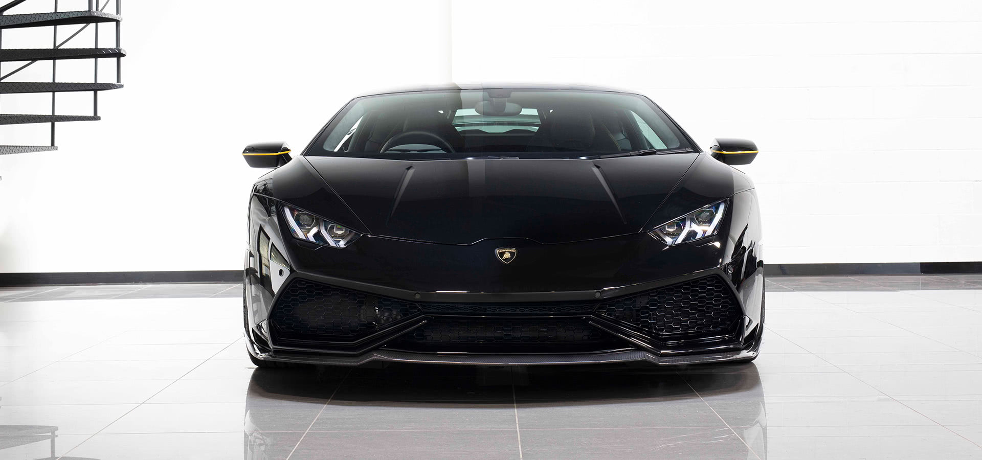 Front view of a black Lamborghini Huracan with the Urban carbon front splitter