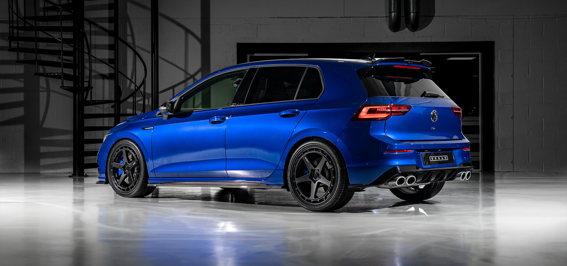 Rear three-quarter view of a blue VW Golf R Mk8 with the Urban carbon aero kit