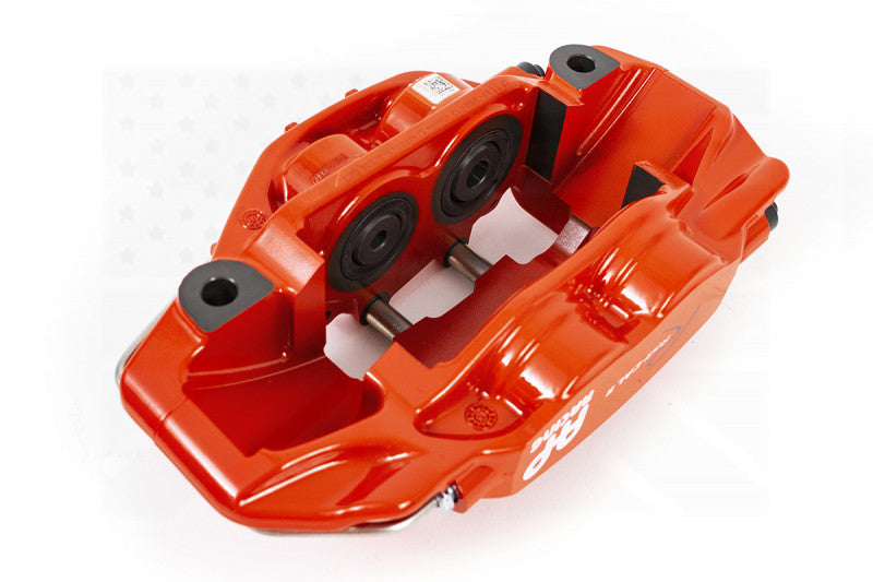 A top side view of the red caliper of the AP Racing by Essex Road Brake Kit (Rear 9541/380mm)- F87 BMW M2, F80 M3, F82 M4 with a white background
