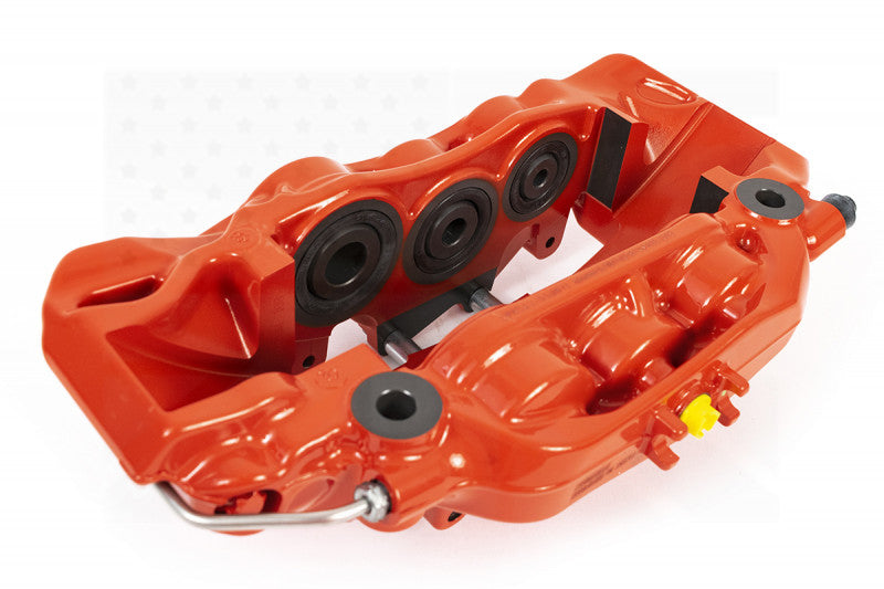 A top view of a red caliper of the AP Racing by Essex Road Brake Kit (Front 9561/380mm)- Tesla Model 3 with a white background