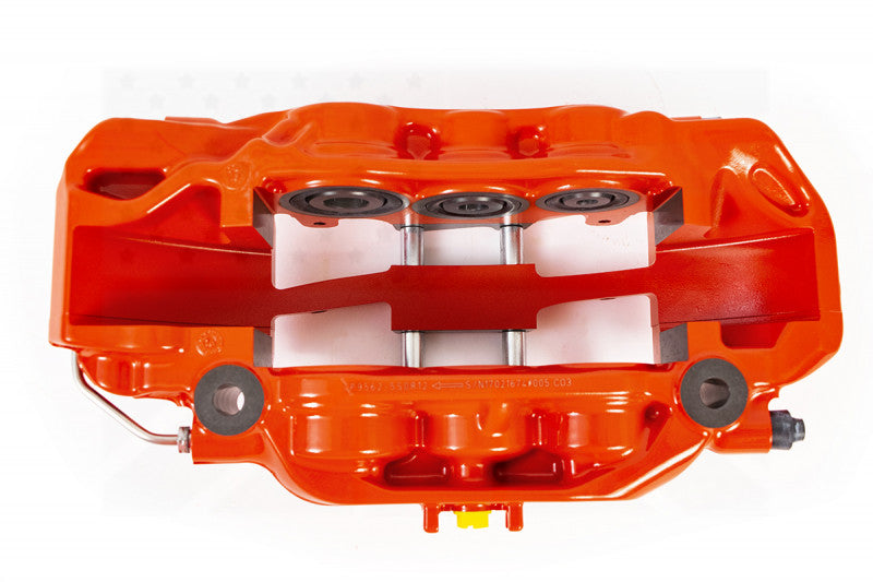 A top view of a red caliper of the AP Racing by Essex Road Brake Kit (Front 9562/380mm)- Porsche 911 (997/991/992) with a white background