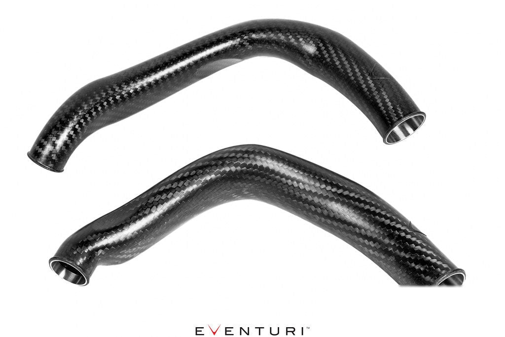 Two curved carbon fiber charge pipes with glossy finish and polished aluminum inlet ends on white background - Eventuri charge pipes for BMW M3