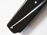 A close up view from the top of AUTOTECKNIC DRY CARBON FIBER SIDE SILL SET - BMW G01 X3 | G02 X4 2018+ with white background