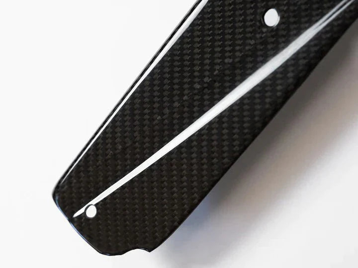 A close up view from the top of AUTOTECKNIC DRY CARBON FIBER SIDE SILL SET - BMW F97 X3M | F98 X4M 2019+ with white background