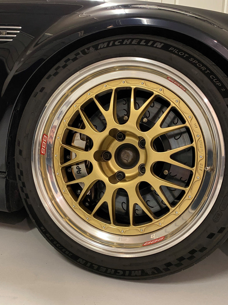 A close up view of a wheel fitted with AP Racing by Essex Radi-CAL ENP Competition Brake Kit (Front CP9660/355mm)- BMW E46 M3