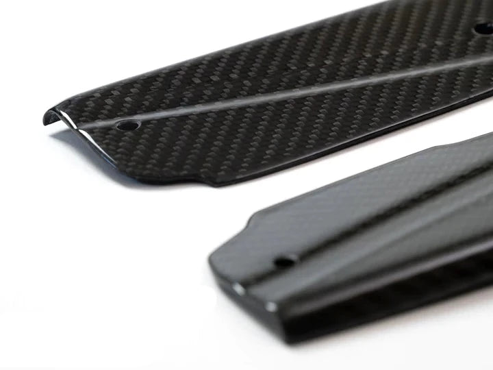A close up view of AUTOTECKNIC DRY CARBON FIBER SIDE SILL SET - BMW G01 X3 | G02 X4 2018+ with white background