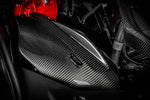 Carbon fiber intake system with weave pattern installed in engine bay with red engine cover visible - Eventuri intake for Toyota Supra