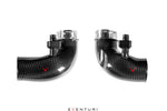 Two carbon fiber curved inlet tubes with metal clamps and red V logos on white background - Eventuri turbo inlet for BMW F90 M5 F91 F92 F93 M8