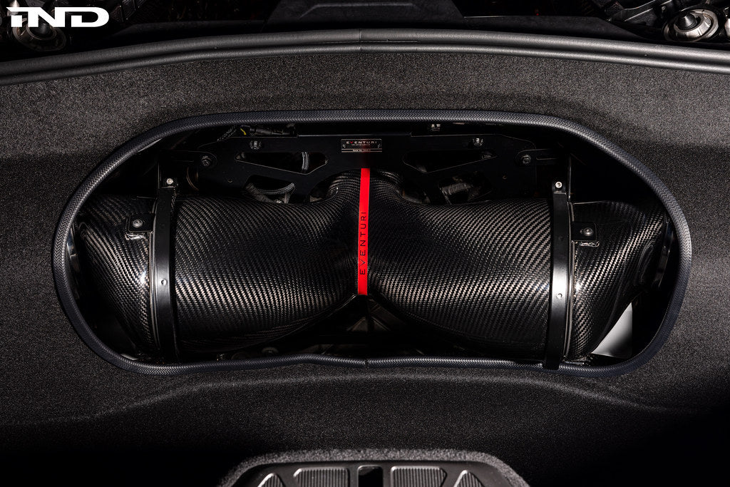 Two cylindrical carbon fiber intake tubes with red center divider installed in Corvette engine bay opening - Eventuri cold air intake for Chevrolet Corvette Stingray