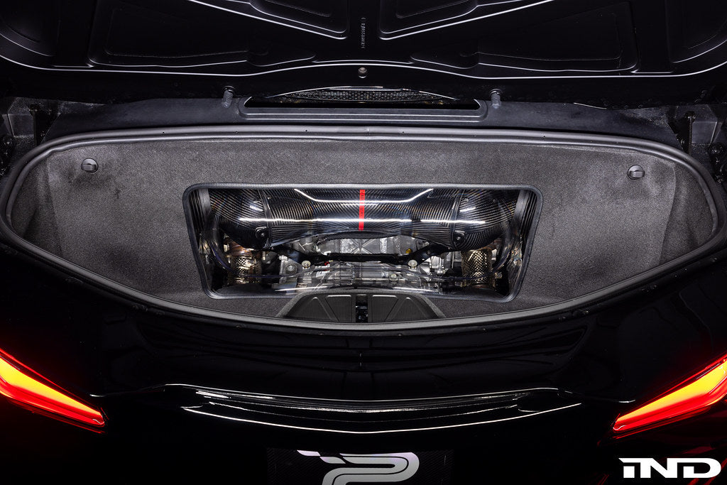 Carbon fiber intake system installed in rear engine bay with visible supercharger and mesh ducting components - Eventuri intake for Chevrolet Corvette Z06