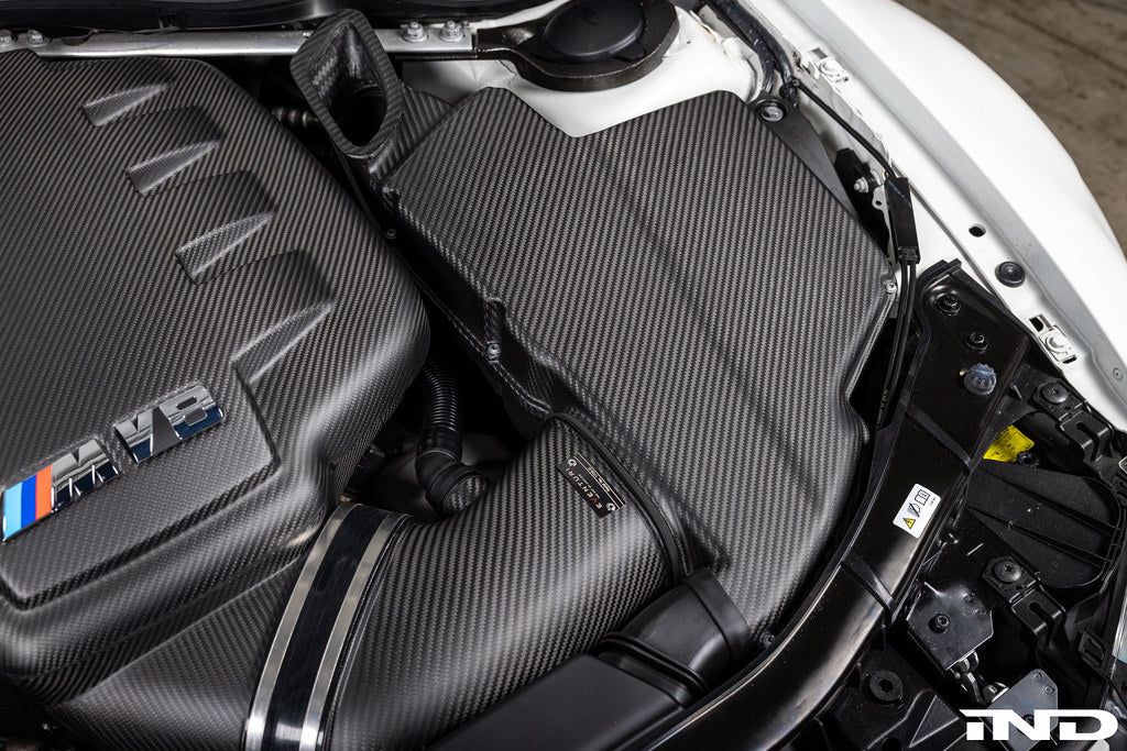 Carbon fiber airbox lid with diagonal weave pattern installed in white BMW M3 engine bay - Eventuri airbox lid for BMW M3