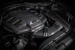 Carbon fiber inlet plenum with angular geometric design installed in engine bay with intake tubes connected - Eventuri inlet plenum for BMW M3