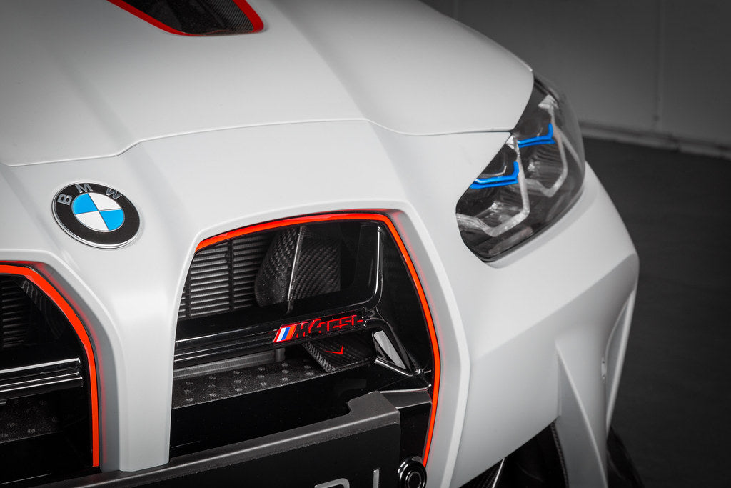 Black carbon fiber intake scoop with angular design installed behind kidney grille opening on white BMW M3 - Eventuri intake scoop for BMW M3
