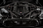 Black carbon fiber strut brace mounted across engine bay strut towers with aluminum brackets and hardware - Eventuri strut brace for BMW M2