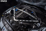 Carbon fiber engine cover installed in BMW M2 engine bay with strut tower brace visible - Eventuri engine cover for BMW M2