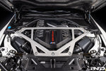 Black carbon fiber engine cover with angular geometric design installed in BMW M2 engine bay with strut tower brace - Eventuri engine cover for BMW M2