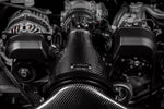Carbon fiber intake tube with woven pattern installed in engine bay surrounded by metal components and hoses - Eventuri cold air intake for Toyota GR 86