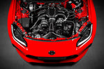 Carbon fiber cold air intake system with curved intake tubes and conical filter installed in red Toyota GR 86 engine bay - Eventuri cold air intake for Toyota GR 86