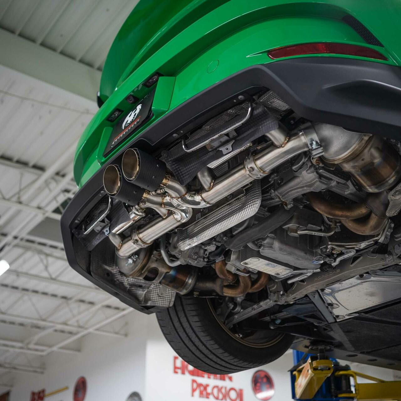 Green Porsche 992 GT3 on a lift with the valved cat-back fitted