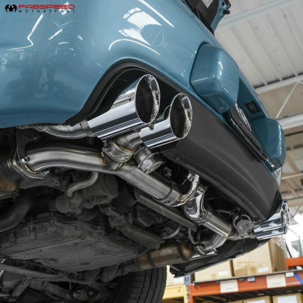 Quad tips of the 997.2 valved exhaust on a blue Porsche 911