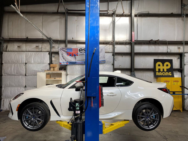 A wide view of a white car with the side wheels fitted with a AP Racing by Essex Radi-CAL Competition Brake Kit (Front CP9660/355mm)- Subaru BRZ, Scion FR-S & Toyota GT86/GR86 2013+