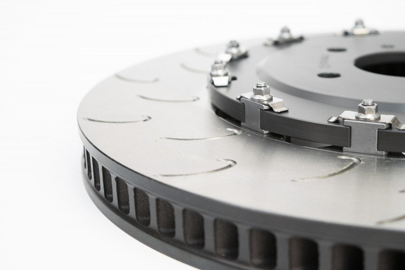 A close up view of the iron discs of the AP Racing by Essex Road Brake Kit (Rear 9541/380mm)- C7 Corvette with a white background